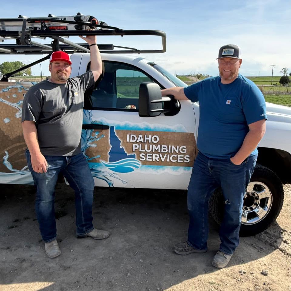 Smilling professional plumbers standing beside an Idaho Plumbing Services service truck ready to provide emergency repairs and installations throughout the Treasure Valley, Idaho.